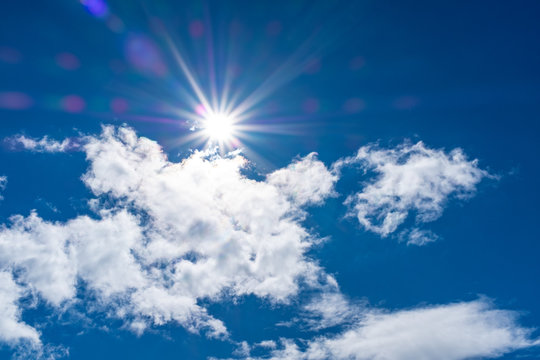 Beautiful Cloudscape With Sun Flair And Star Against A Blue Sky