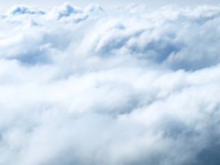 Blurred image of the clouds shoot from the top out of the airplane window.