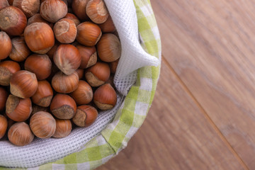 hazelnuts: many nuts lie in a basket on a wooden background