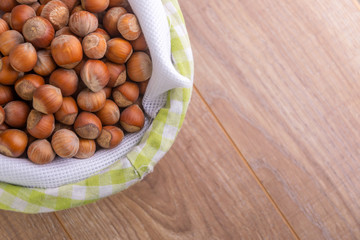hazelnuts: many nuts lie in a basket on a wooden background