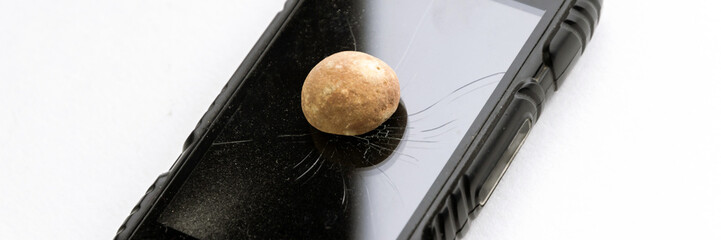 glass of the phone is covered with concentric cracks, there is a stone on the glass, short focus, toning