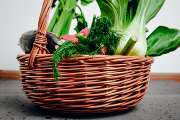 Wicker basket full of vegetables and fruits. View of vegetables. Concept of eating vegetables, using vegetables for dishes. Dish for a vegetarian. Healthy nutrition, vitamins.