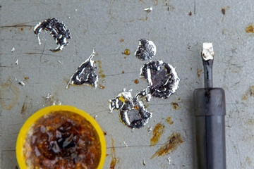 soldering iron with rosin and tin, drops of molten metal, selective focus, close