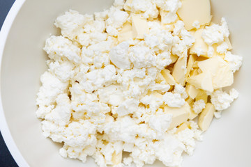In a mixing bowl are the ingredients butter and cottage cheese for making cookies