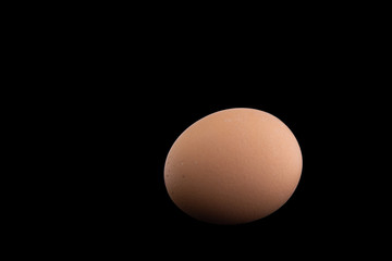 proper nutrition: chicken egg is isolated on a black background with shadows