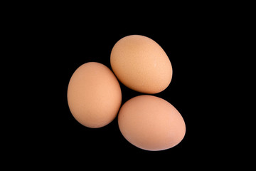 proper nutrition: 3 chicken eggs isolated on a black background with shadows