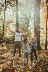 Rodzina bawi się w lesie jesień liście zabawa radość zdrowie szczęście - obrazy, fototapety, plakaty