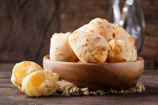 Cheese buns in wooden bowl, rustic kitchen table background, copy space, selective focus