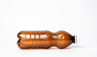 A plastic brown bottle on a white background. Concept of caring for the environment, recycling. Secondary plastic circuit. Environment pollution.