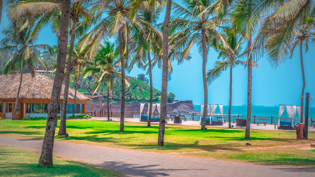 North Goa, India - Candolim beach from Taj Holiday resort with Aguada fort. Famous tourist summer vacations destination on the beach by Arabian Sea in Goa tropical climate with coconut palms.