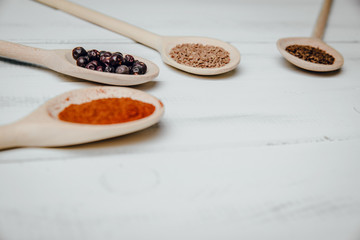 Top view on a set of spices on a wooden table. The concept of using seasonings for dishes, various spices on wooden spoons.