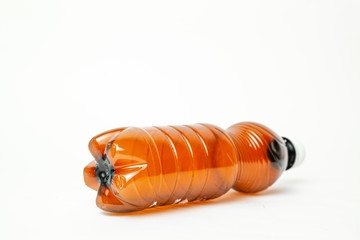 A plastic brown bottle on a white background. Concept of caring for the environment, recycling. Secondary plastic circuit. Environment pollution.