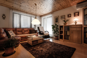 Classically furnished living room in wooden design with old fashioned accessories like lights,...