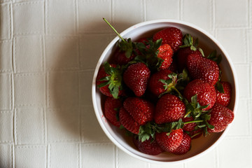 Red fresh strawberry in a bowl on white background with copy space
