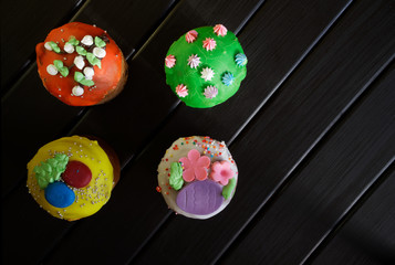 Delicious, colorful cupcakes - Easter cakes and a cup of tea on a black wooden surface. Country breakfast. Homemade. Daylight