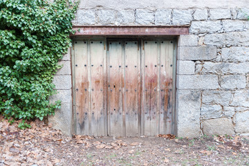 Old wooden door belonging to housing located in country village.