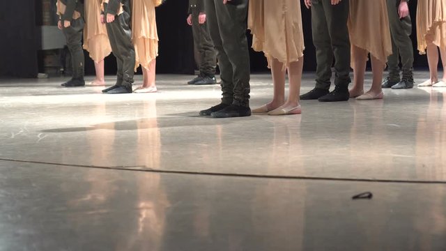 Close-up of female legs dancing cheerfully on stage.