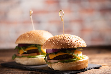 hamburger with lettuce, cheddar cheese, onions, tomato