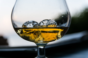 Glass of whisky on ice in a snifter glass