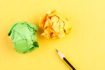 graphite wooden pencil and crumple paper lkon yellow background
