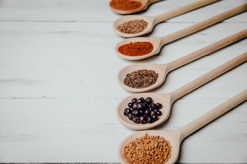 Top view on a set of spices on a wooden table. The concept of using seasonings for dishes, various spices on wooden spoons.