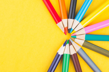 close-up image of Colourful pencils over yellow background