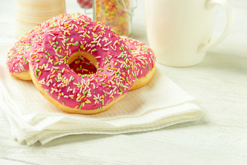 Donut on a kitchen towel and on a wooden table. Photo of sweets.