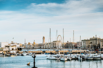Bari, Italy - March 10, 2019: Sunset view of the touristic seafront and port of Bari, with its ferris wheel in the background.