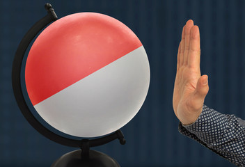 gesture of a male hand warns against the globe, which depicts a colored national state flag...