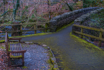 The chair sat before crossing the old stone bridge over the beautiful river.