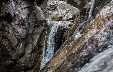 Fototapeta na wymiar flow of water between the rocks of a mountain stream
