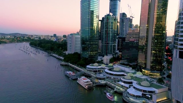 Aerial shot of the Brisbane River near Eagle Street Pier at dusk, showing yachts moored near the Botanical Gardens in Queensland Australia.