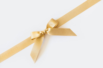 Fototapeta premium Gold ribbon with a bow as a gift on a white background