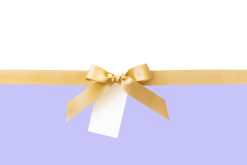 Fototapeta premium Gold ribbon with a bow as a gift on a white and violet background
