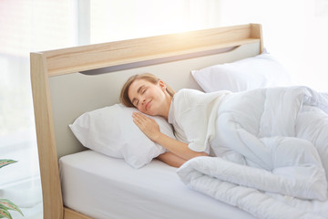 young beautiful woman sleeping in bed with relaxation and happy face in the morning