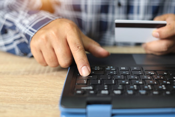 man hands shopping and online payment by using laptop with credit card