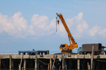 Fototapeta na wymiar Crane truck for lifting a material supply to the trucks on the dock.