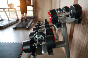 Fototapeta premium dumbell set on the rack in fitness gym with sunlight effect
