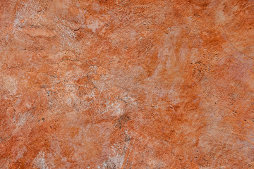 Adobe wall painted with wide brush strokes in warm light brown color