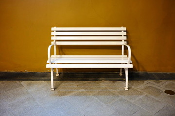 White Iron Bench with Brown Concrete Background.