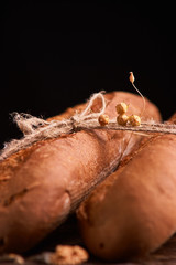 Two Fresh baguettes on dark wooden table. Selective focus