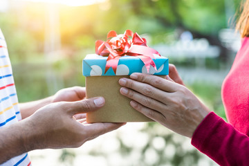 Closeup on hands male and female giving a gift box with copy space for Birthday, Christmas and New year, Valentine's, Graduate, Celebrate.  