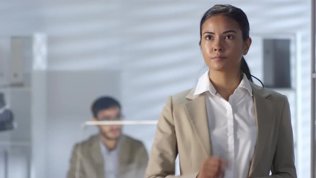 Young Asian businesswoman swiping and tapping on invisible multi-touch screen while working in office with male colleagues. Suitable for adding AR graphics