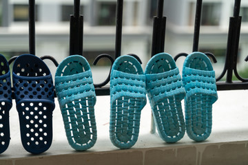 Slippers, washed and then dried in the sun in balcony of apartment building