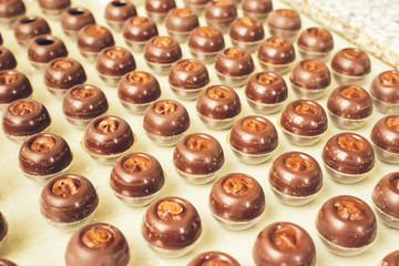 Dark chocolate candies are arranged rows special shapes. Cooking handmade chocolates. Selective focus. Horizontal frame.