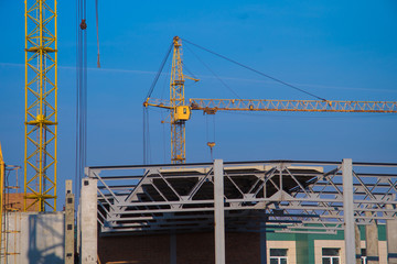 Obraz na płótnie Canvas building crane and construction site over clear blue sky background