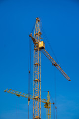 building cranes over clear blue sky background