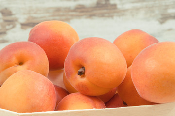Fresh apricot in wooden box as healthy snack or dessert containing vitamins
