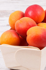 Fresh apricot in wooden box as healthy snack or dessert containing vitamins