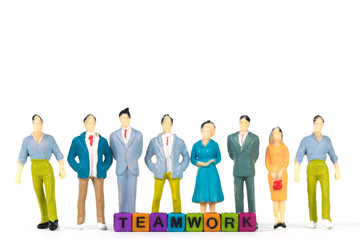 TEAMWORK text and Group of figure miniature businessman or small people investor and office worker secretary on white background for money and financial business teamwork concept.